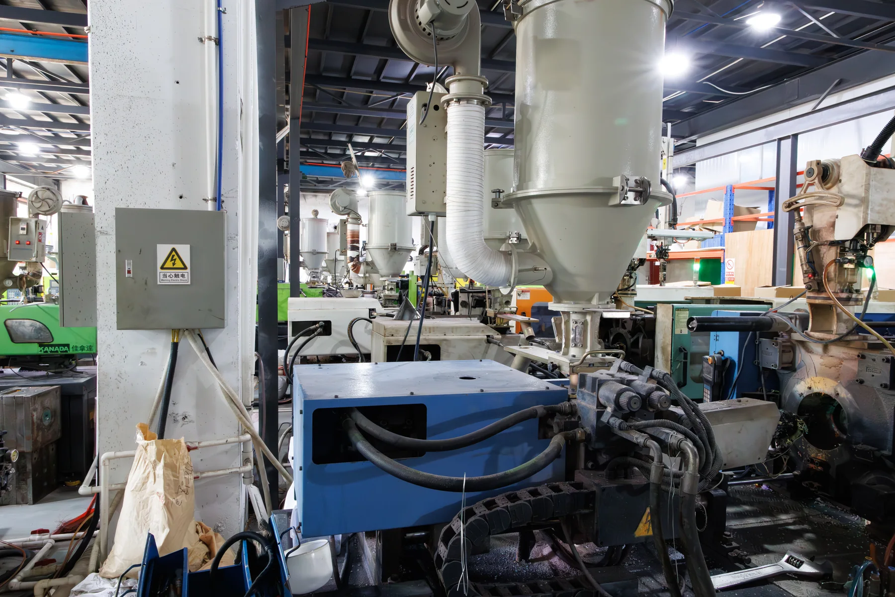 Material hopper, hoses and controls on an injection molding machine